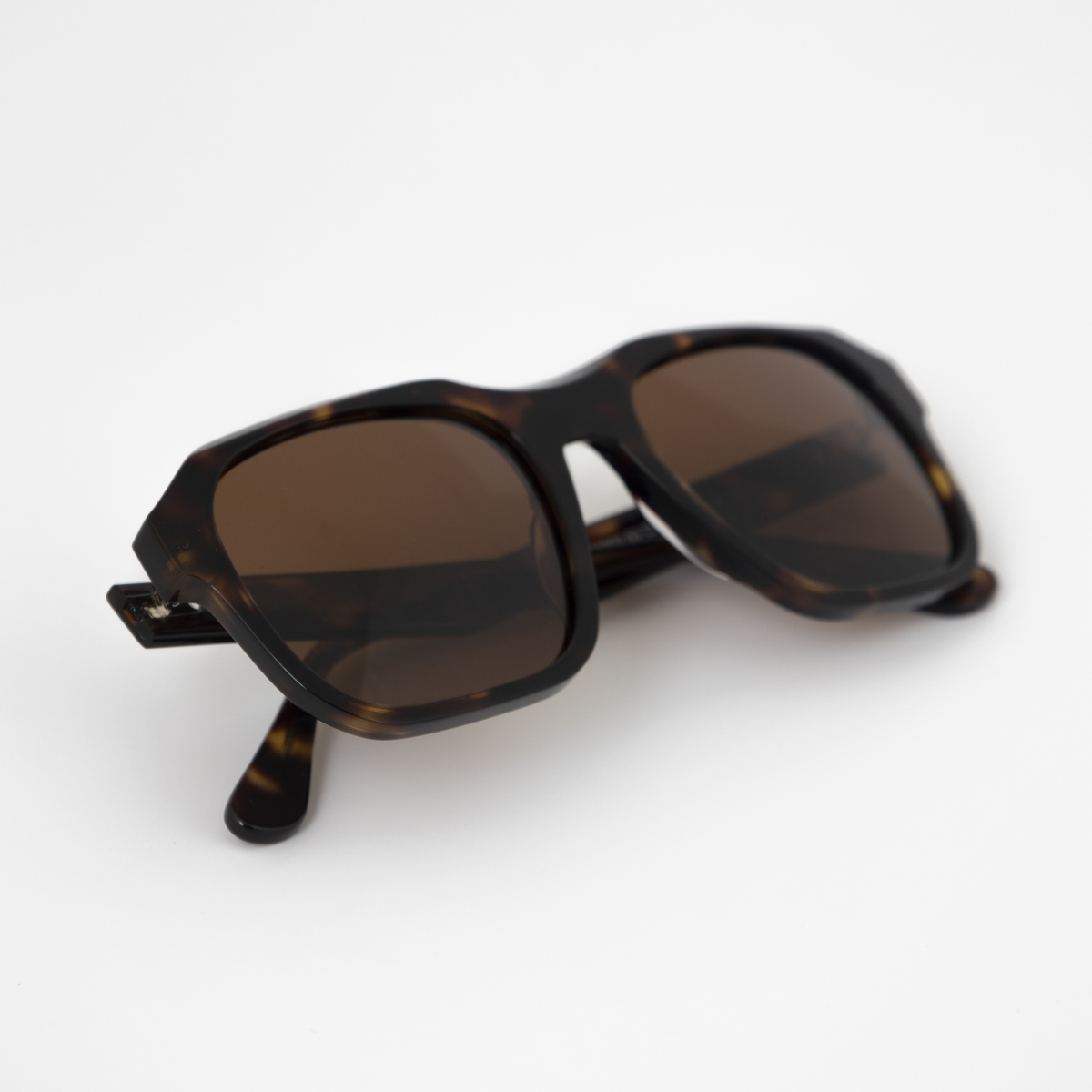 Gafas de sol Dubai – Detalles del diseño para resistir el desierto. Gafas de sol Dubai sobre suelo, mostrando su diseño y cuidado.